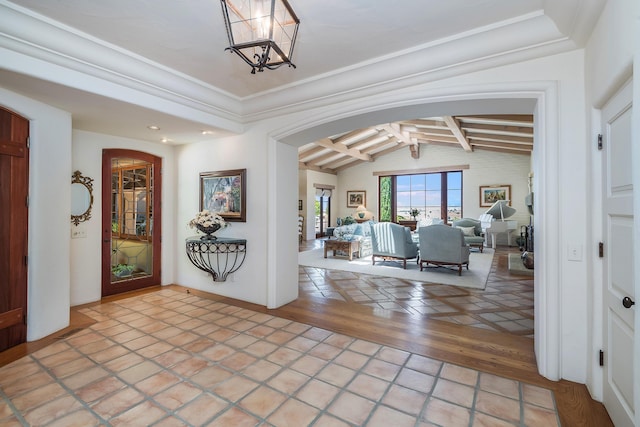 entrance foyer with vaulted ceiling with beams, ornamental molding, and hardwood / wood-style floors