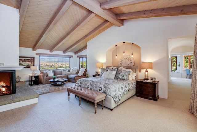 bedroom featuring beamed ceiling, light colored carpet, multiple windows, and wooden ceiling