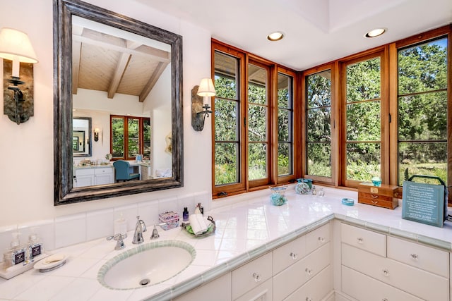 bathroom featuring vanity and vaulted ceiling with beams