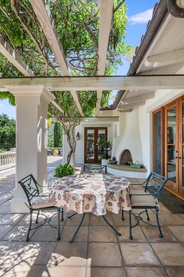 view of patio / terrace with a bar, exterior fireplace, and french doors