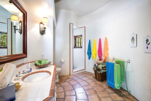 bathroom featuring walk in shower, vanity, and toilet