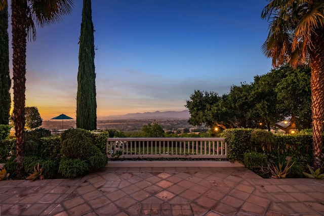 patio terrace at dusk featuring a mountain view