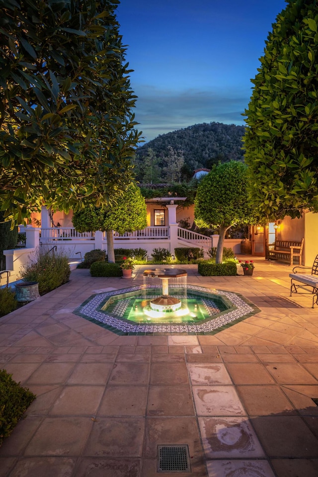 pool at dusk with a mountain view and a patio