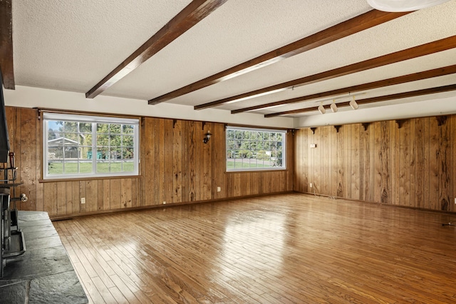 2385 Janin Pl, Solvang, CA 93463 - unfurnished living room with beamed ceiling, hardwood / wood-style flooring, wooden walls, and a textured ceiling