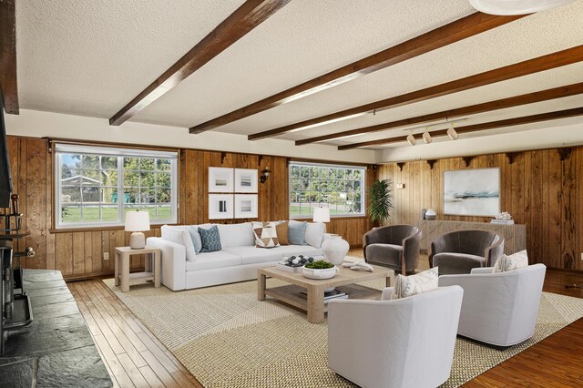 2385 Janin Pl, Solvang, CA 93463 - living room featuring beamed ceiling, hardwood / wood-style floors, a textured ceiling, and wood walls