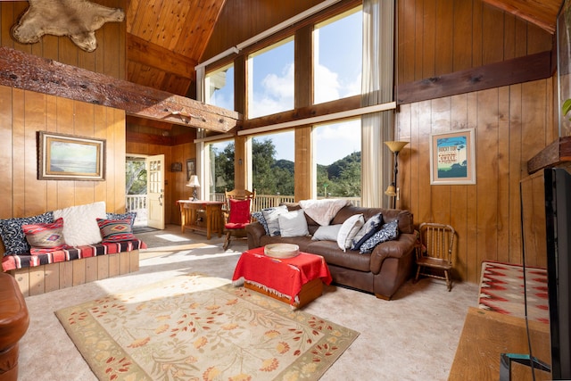 carpeted living room with wood ceiling, wooden walls, and high vaulted ceiling