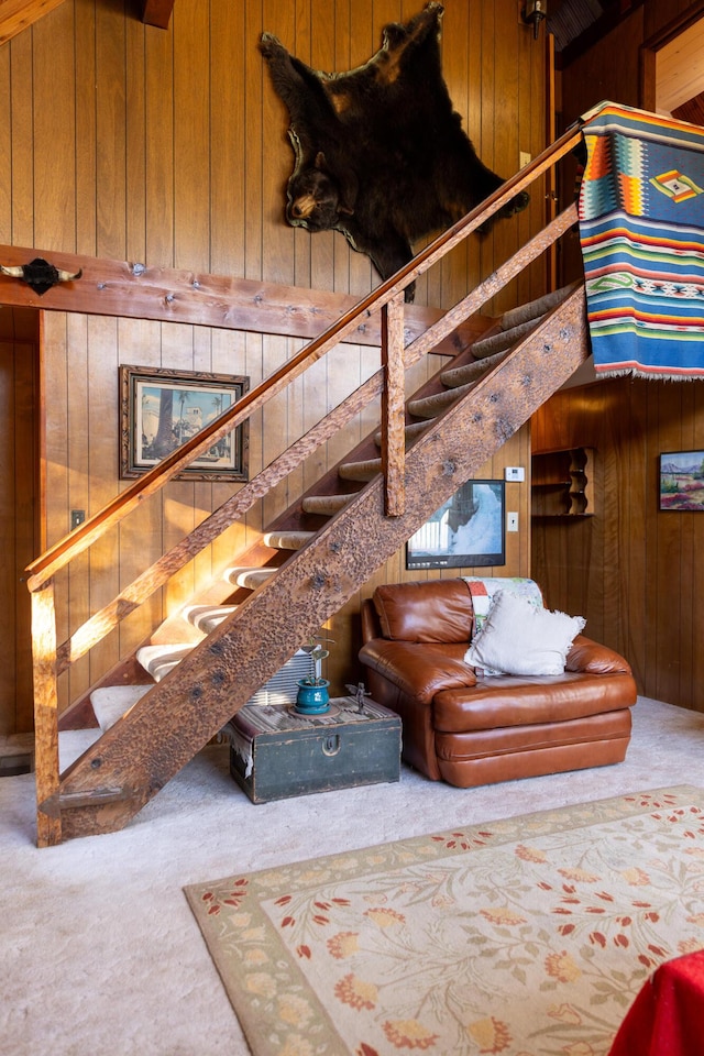 carpeted living room featuring wooden walls