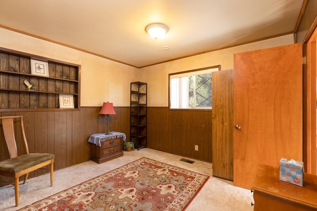 carpeted office space featuring ornamental molding and wood walls