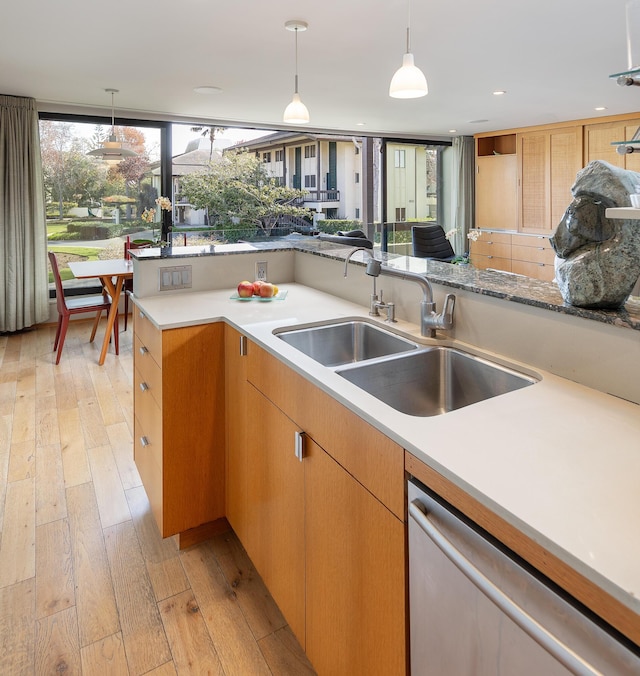 kitchen with sink, light wood-type flooring, hanging light fixtures, and dishwasher