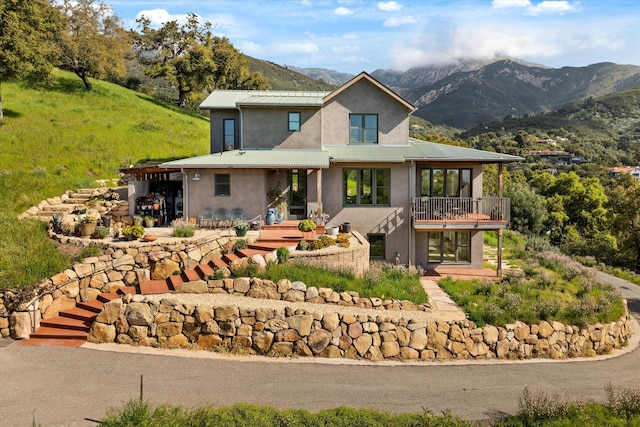 rear view of property featuring a mountain view, stairway, and stucco siding