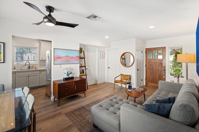 living room with sink, light hardwood / wood-style floors, and ceiling fan