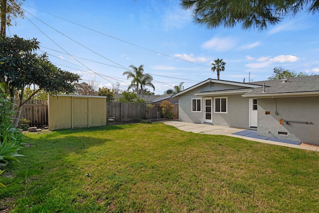 view of yard with an outbuilding, a patio area, a fenced backyard, and a storage shed