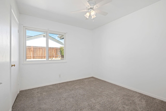 empty room featuring carpet floors, a ceiling fan, and baseboards