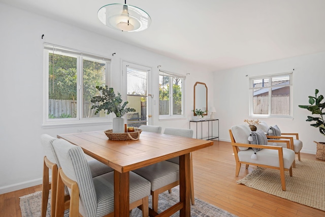 dining area with light wood-style flooring and baseboards