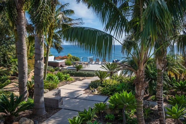 view of community with a water view and a patio area