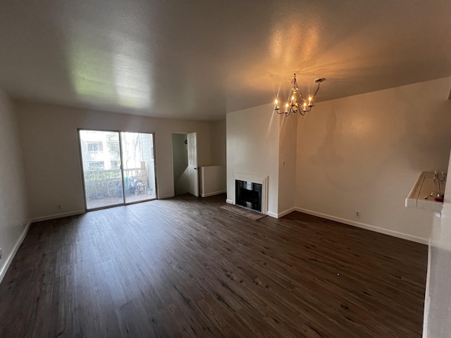 unfurnished living room with dark hardwood / wood-style floors and a notable chandelier