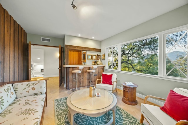 living room with visible vents, baseboards, recessed lighting, and bar area