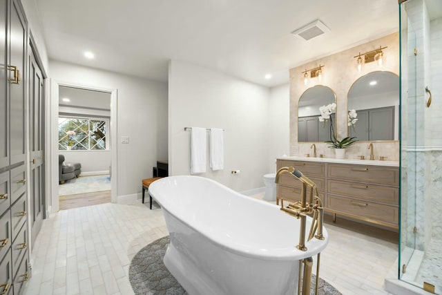 bathroom with recessed lighting, a shower stall, double vanity, a sink, and a soaking tub