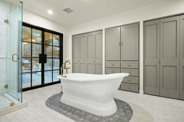 full bath featuring a closet, a soaking tub, visible vents, and a stall shower