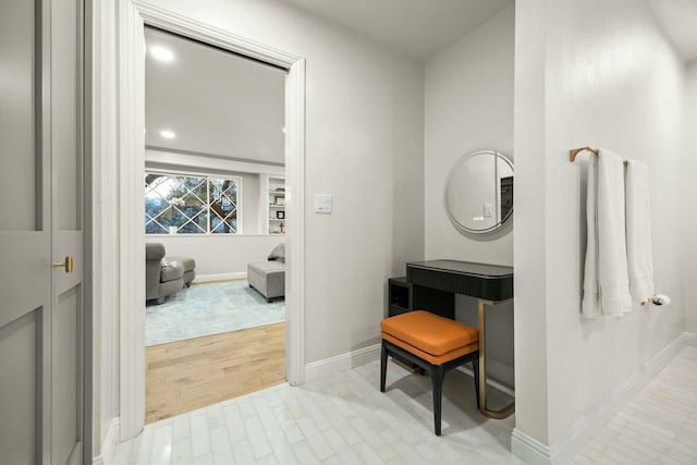 hall featuring wood finished floors and baseboards