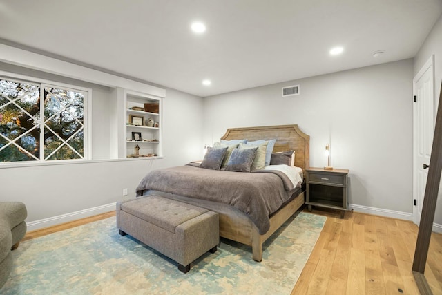 bedroom with light wood finished floors, baseboards, and recessed lighting