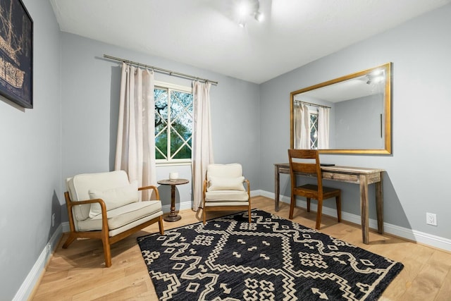 sitting room with baseboards and wood finished floors