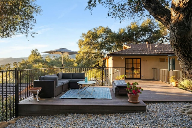 deck featuring an outdoor living space, french doors, and a mountain view