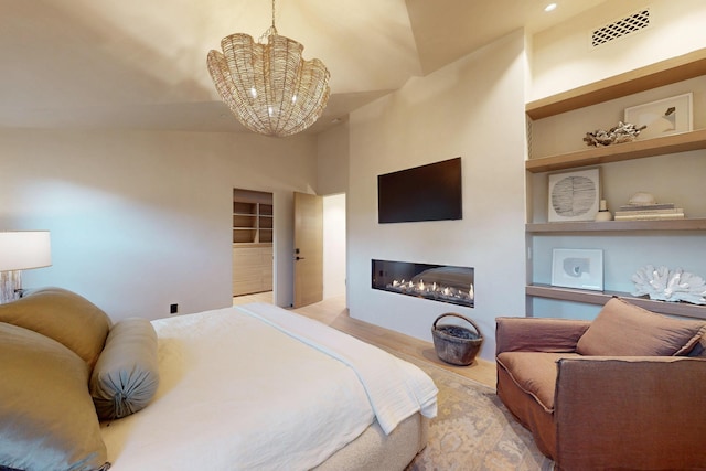 670 Santa Lucia Ave, Los Osos, CA 93402 - bedroom featuring a chandelier, a high ceiling, a glass covered fireplace, and visible vents