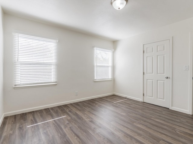 empty room with dark hardwood / wood-style flooring