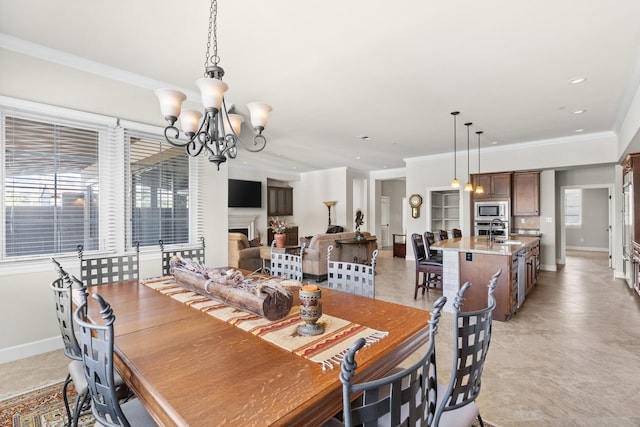 dining room with ornamental molding, sink, plenty of natural light, and a chandelier