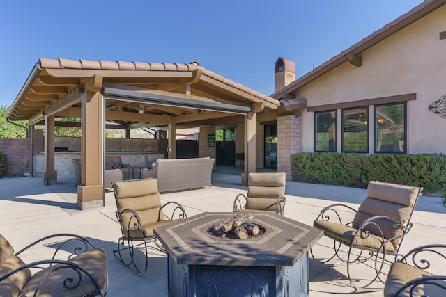 view of patio featuring an outdoor fire pit, area for grilling, and ceiling fan