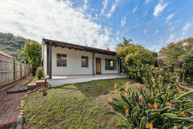 back of property with a patio area, fence, and stucco siding