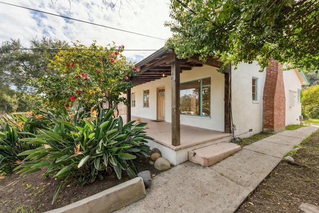 view of property exterior with crawl space and stucco siding