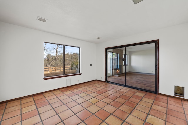 tiled spare room featuring baseboards