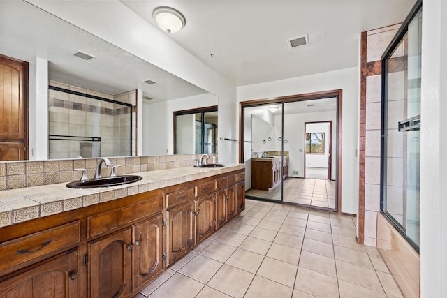 full bathroom with tasteful backsplash, visible vents, a sink, and tile patterned floors