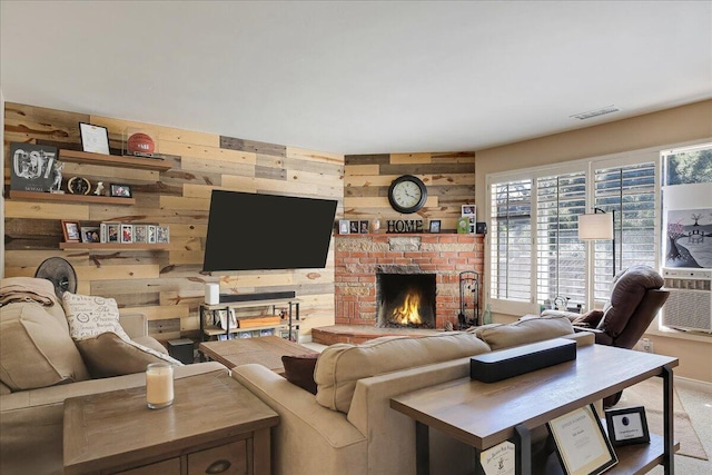 living area featuring carpet floors, visible vents, a fireplace, and wooden walls