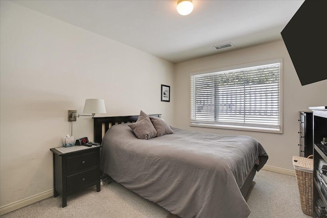 bedroom featuring visible vents, baseboards, and light colored carpet