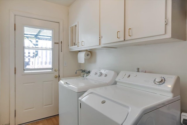 laundry room featuring light wood-type flooring, cabinet space, and washer and clothes dryer