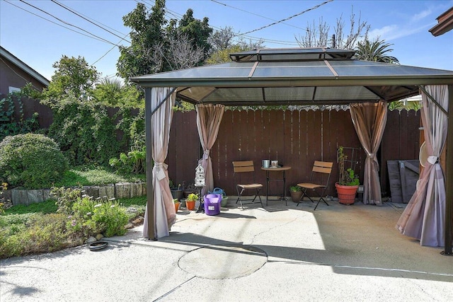 view of patio featuring fence and a gazebo