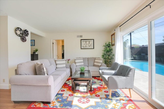 living area with visible vents and light wood-style floors