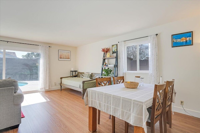 dining space with baseboards and light wood-style floors