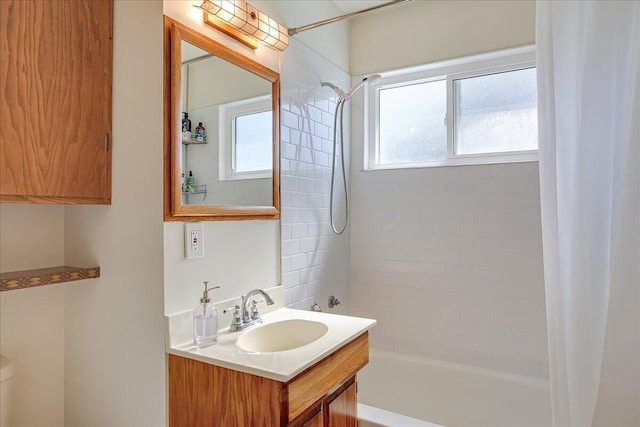 full bathroom with a healthy amount of sunlight, vanity, and shower / bathtub combination