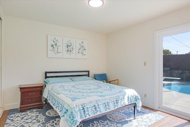 bedroom with access to exterior, baseboards, and wood finished floors