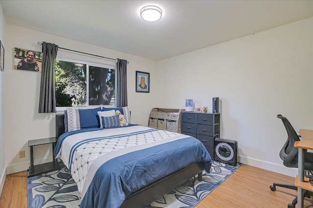 bedroom with light wood finished floors and baseboards