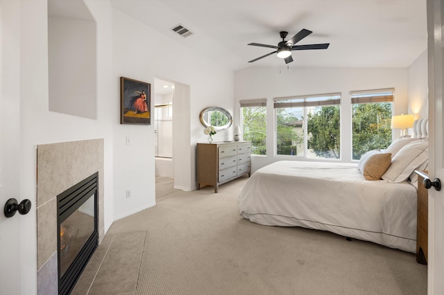 carpeted bedroom with baseboards, visible vents, connected bathroom, vaulted ceiling, and a fireplace