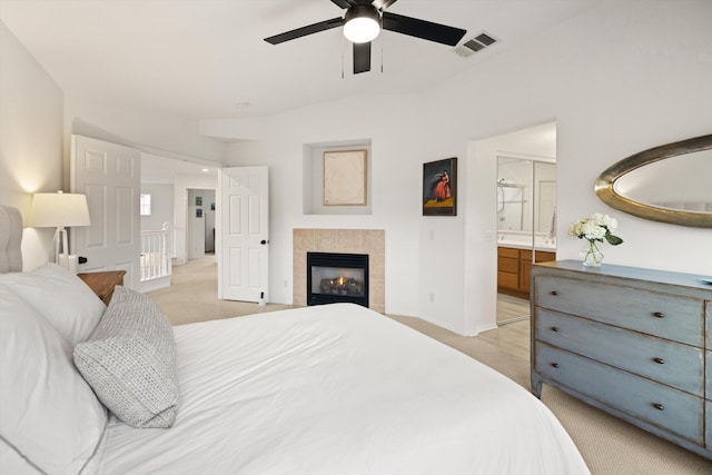 bedroom featuring light carpet, baseboards, visible vents, connected bathroom, and a fireplace