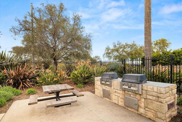 view of patio featuring exterior kitchen, grilling area, and fence