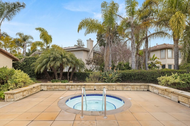 view of pool with an in ground hot tub and a patio