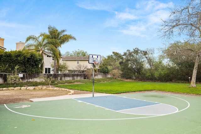 view of sport court with community basketball court, fence, and a yard