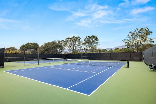 view of sport court with fence and a mountain view